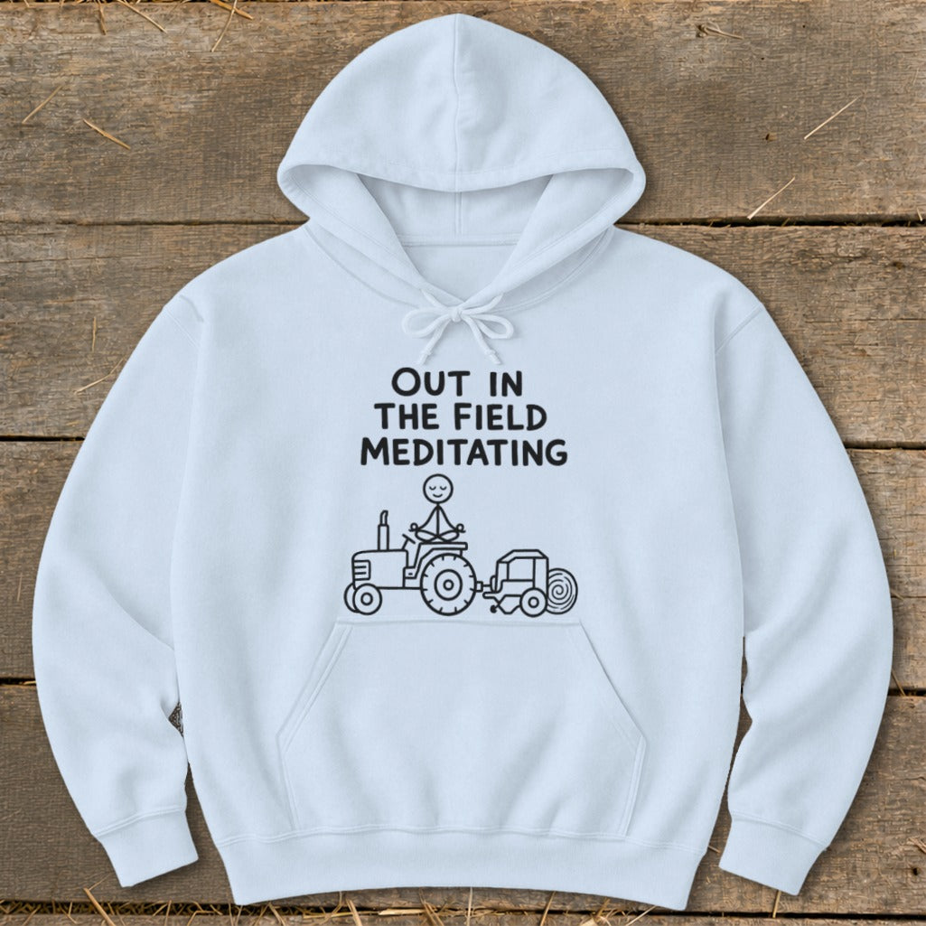 White hoodie with black text and drawing of stick figure meditating on a tractor.