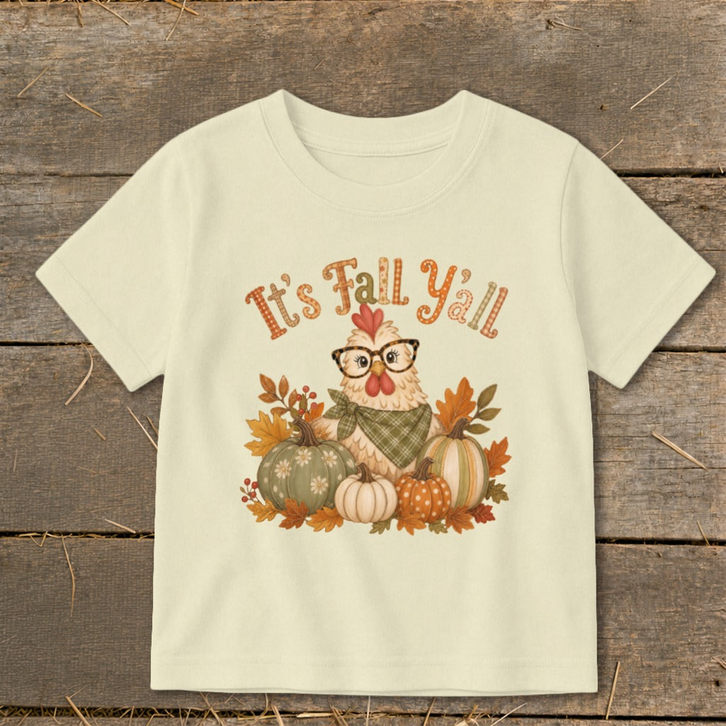 Chicken with glasses and pumpkins, reads "It's Fall Y'all" on a cream t-shirt.