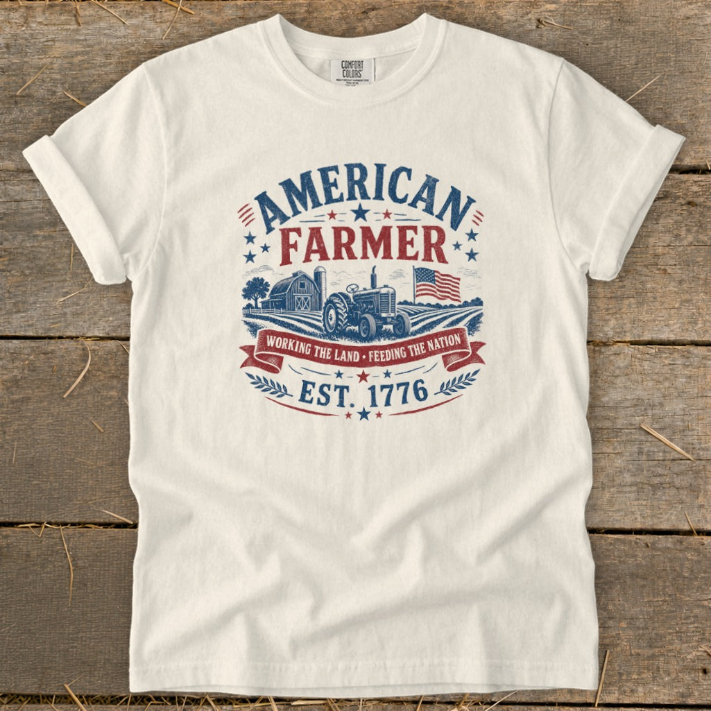 White t-shirt with "American Farmer" graphic, tractor, barn, flag, and "Est. 1776".