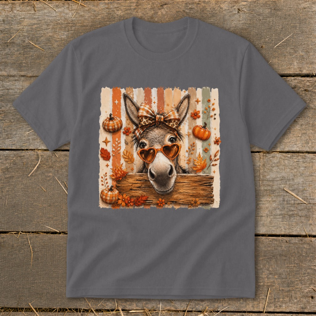 Donkey wearing heart sunglasses and bow with fall pumpkins and leaves.