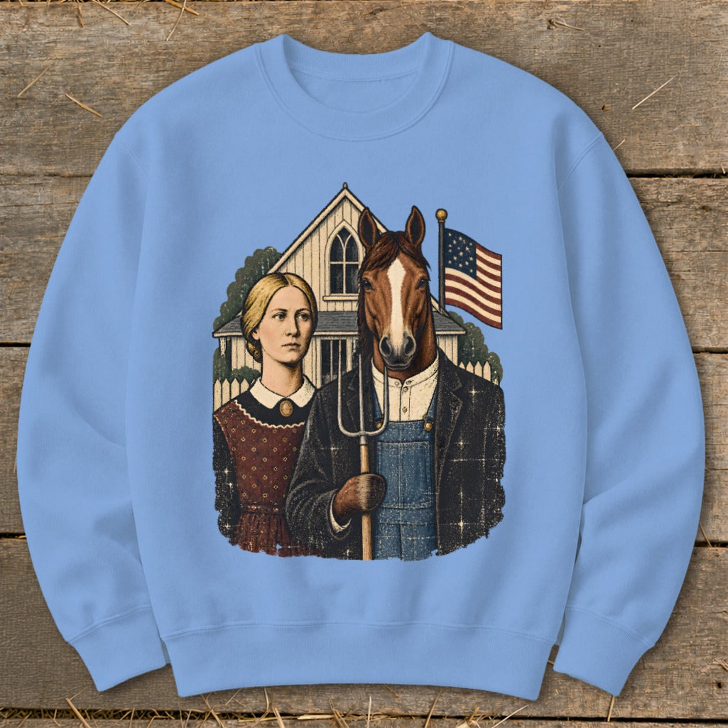A light blue crewneck sweatshirt featuring a graphic parody of American Gothic with a horse head on the farmer.
