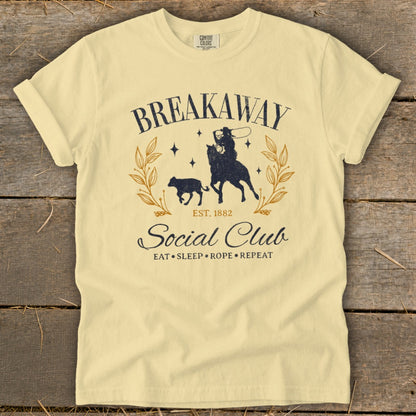 Cream t-shirt with "Breakaway Social Club" graphic of a cowboy on a horse roping a calf.