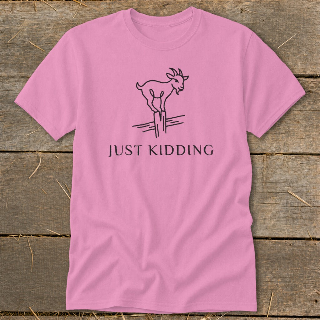 Pink t-shirt with a black line drawing of a goat on a post and the text "JUST KIDDING".