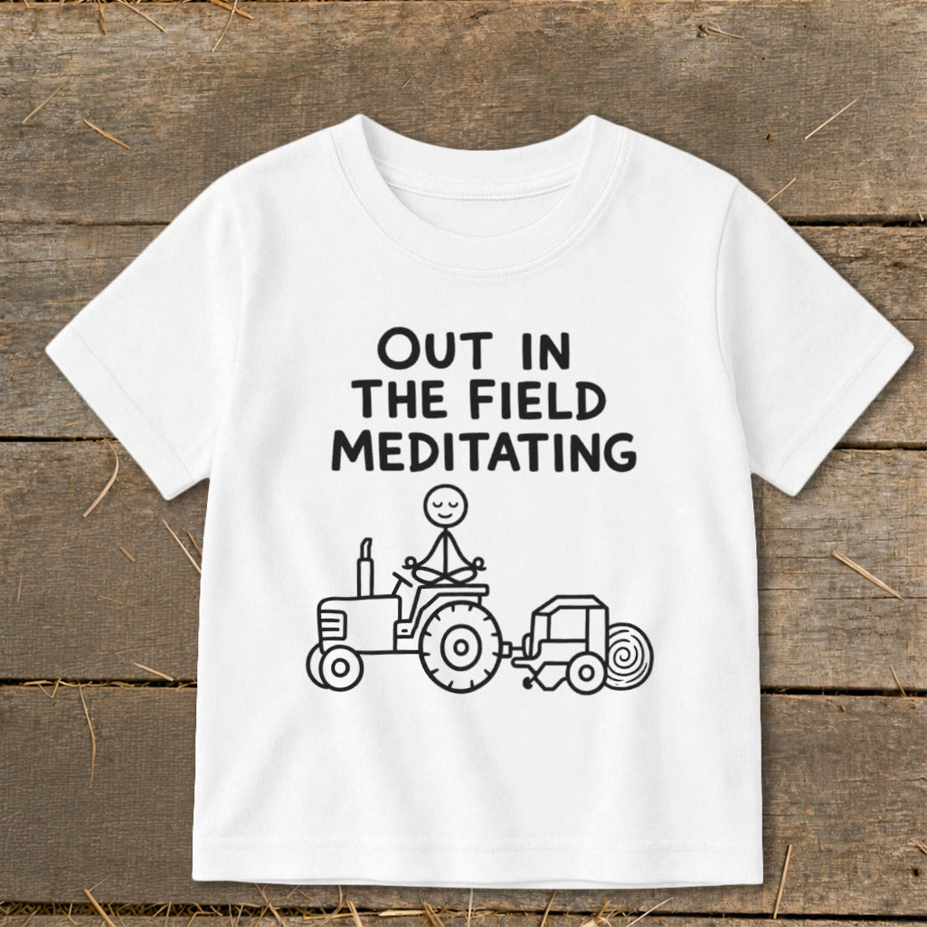 White t-shirt with black text and drawing of a meditating stick figure on a tractor.