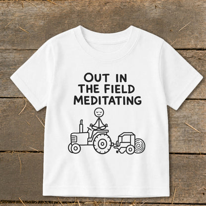 White t-shirt with black text and drawing of a meditating stick figure on a tractor.