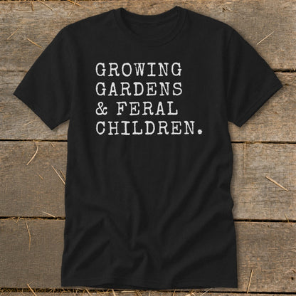 Black t-shirt with white text reading "GROWING GARDENS & FERAL CHILDREN."