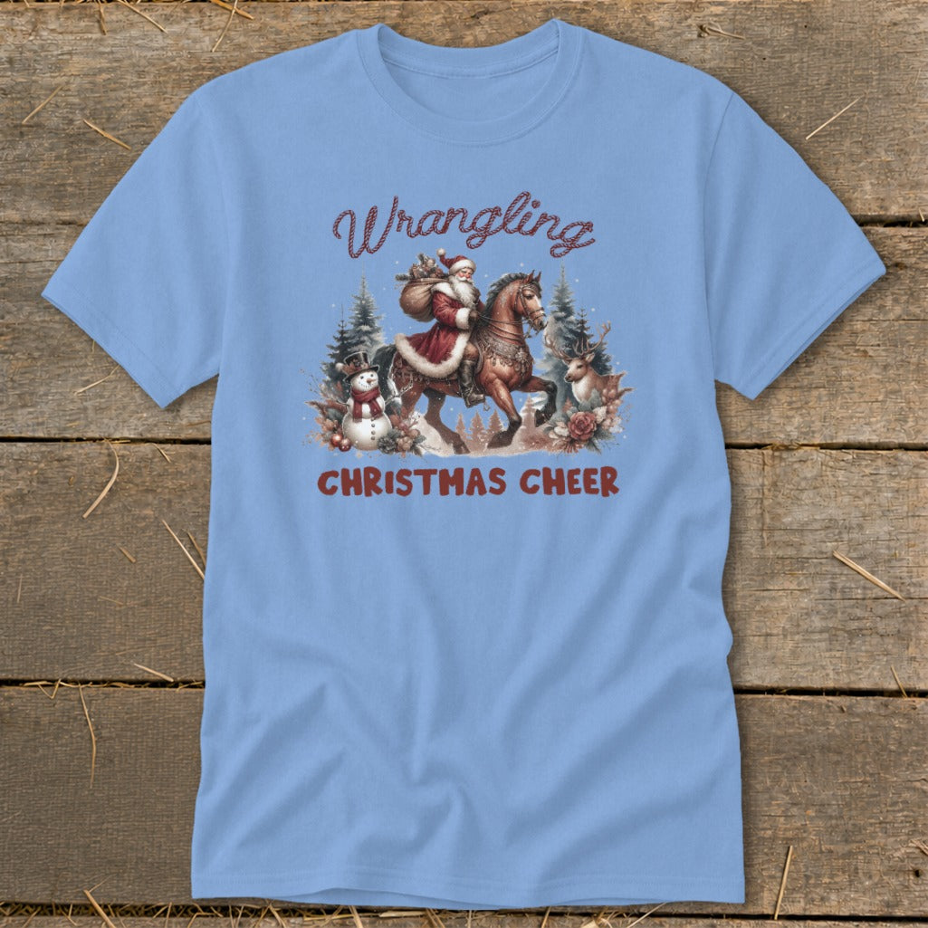Light blue t-shirt with Santa on horseback, snowman, deer, and text "Wrangling Christmas Cheer".