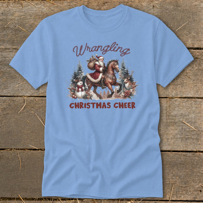Light blue t-shirt with Santa on horseback, snowman, deer, and text "Wrangling Christmas Cheer".