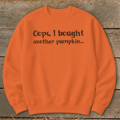 Orange crewneck sweatshirt with black text reading "Oops, I bought another pumpkin..."