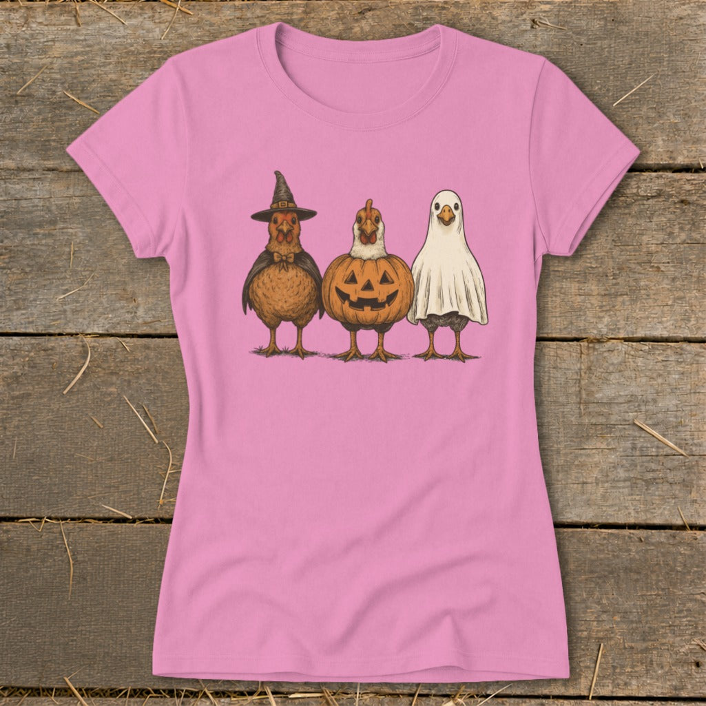 Three chickens dressed for Halloween: witch, jack-o'-lantern, and ghost.