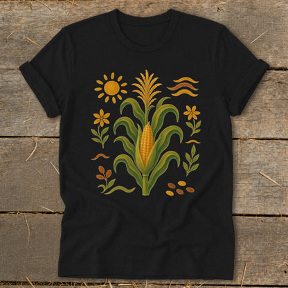 Black t-shirt with a central corn stalk and surrounding floral, sun, and wavy line design.