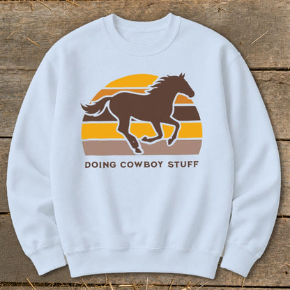 Light blue sweatshirt with brown horse silhouette and "Doing Cowboy Stuff" text.