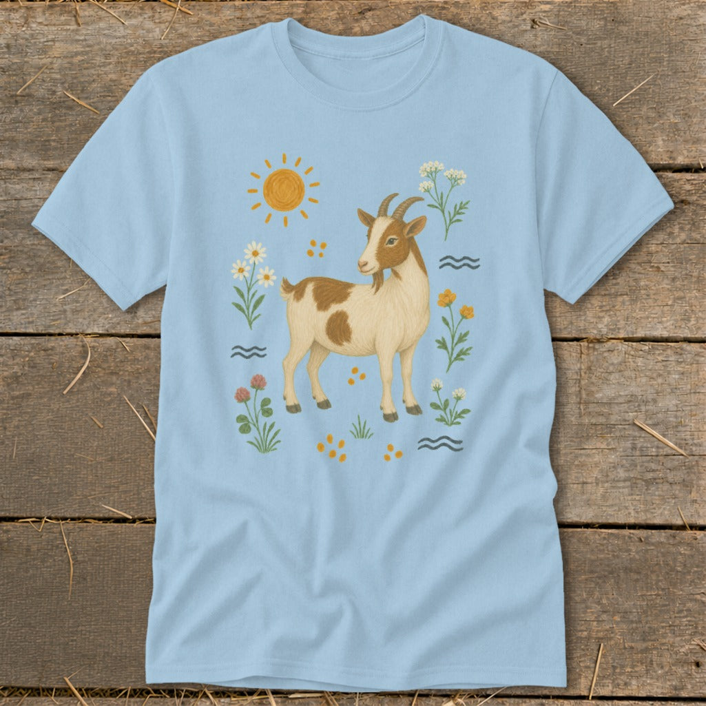 Light blue t-shirt with a brown and white goat surrounded by flowers, sun, and wavy lines.