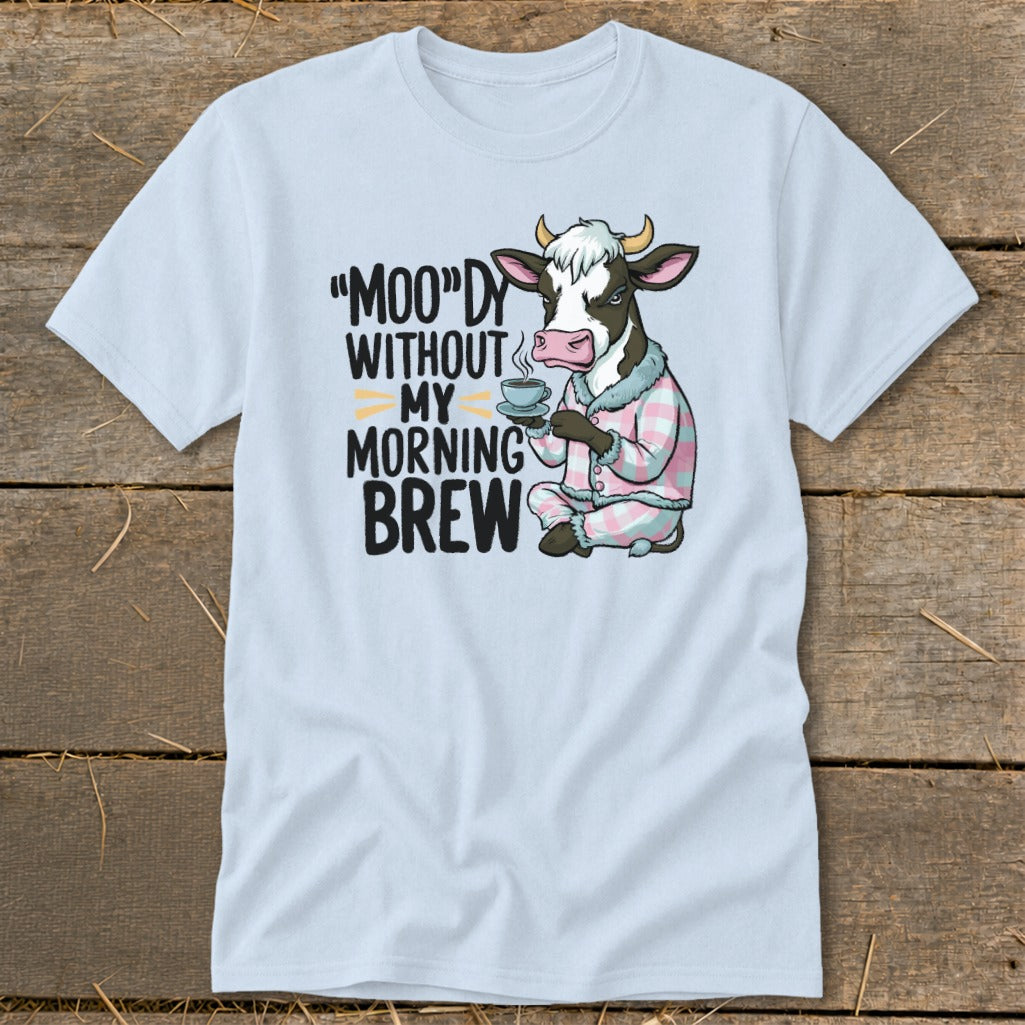 Light blue t-shirt with a cartoon cow in pajamas holding coffee and text "MOO"dy without my morning brew."