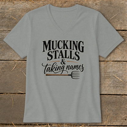 Grey v-neck t-shirt with text "Mucking Stalls & Taking Names" and a pitchfork.