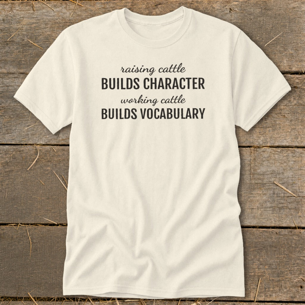 Cream t-shirt with text "raising cattle BUILDS CHARACTER working cattle BUILDS VOCABULARY".