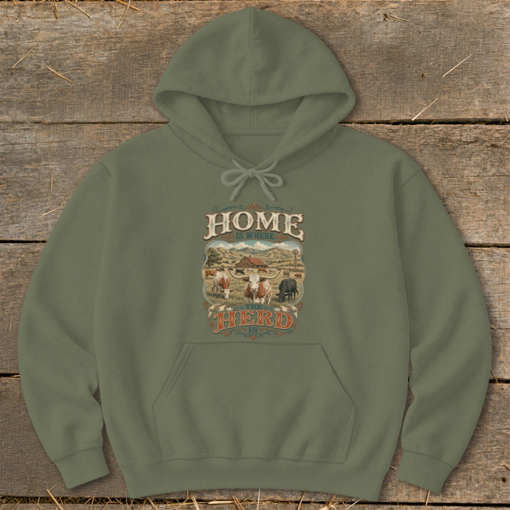 Olive green hoodie with "HOME IS WHERE THE HERD IS" graphic featuring cows and a barn.