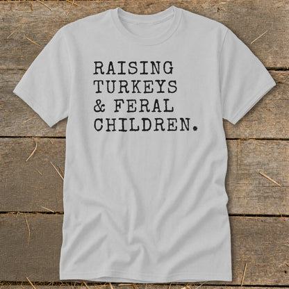 Light grey t-shirt with black text "RAISING TURKEYS & FERAL CHILDREN."