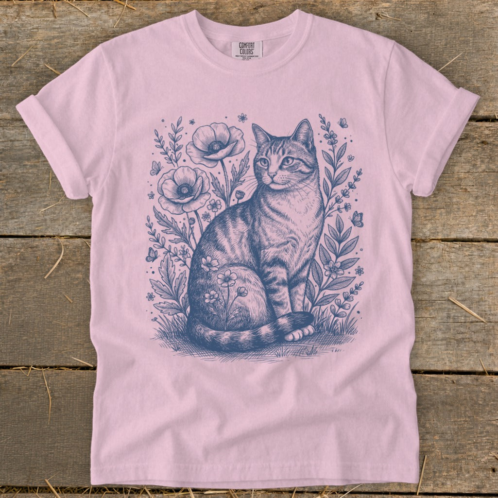 Pink t-shirt with a blue line drawing of a tabby cat among flowers and butterflies.