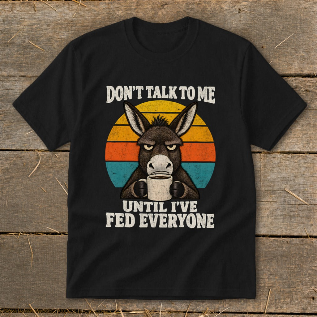 A black t-shirt features an angry donkey holding a coffee mug against a retro sunset, with text reading "DON'T TALK TO ME UNTIL I'VE FED EVERYONE."
