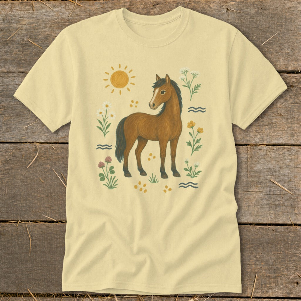 Pale yellow t-shirt with a brown horse, sun, and floral illustrations.