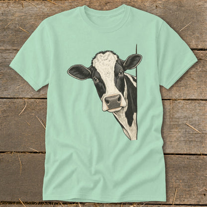Black and white cow peeking from behind a corner on a pale green t-shirt.