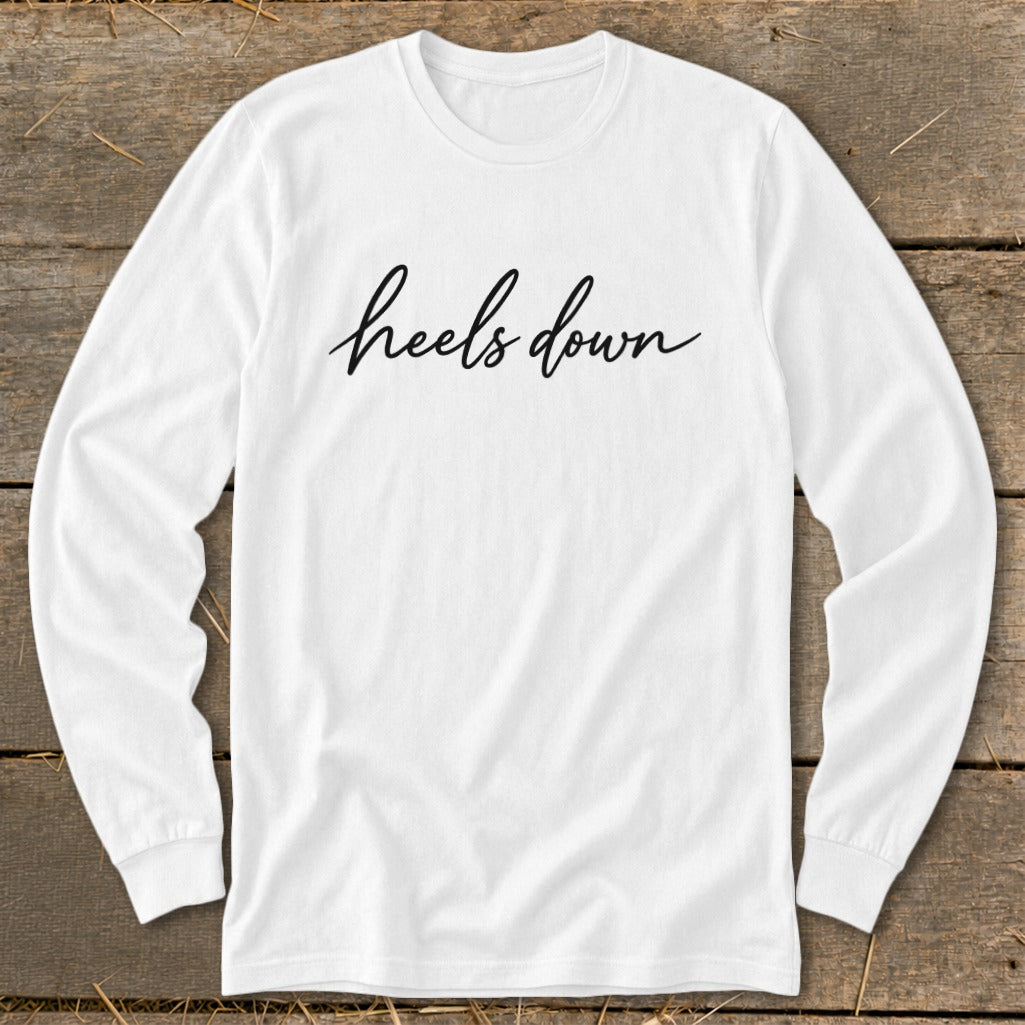 White long-sleeve shirt with "heels down" text in black cursive lettering.