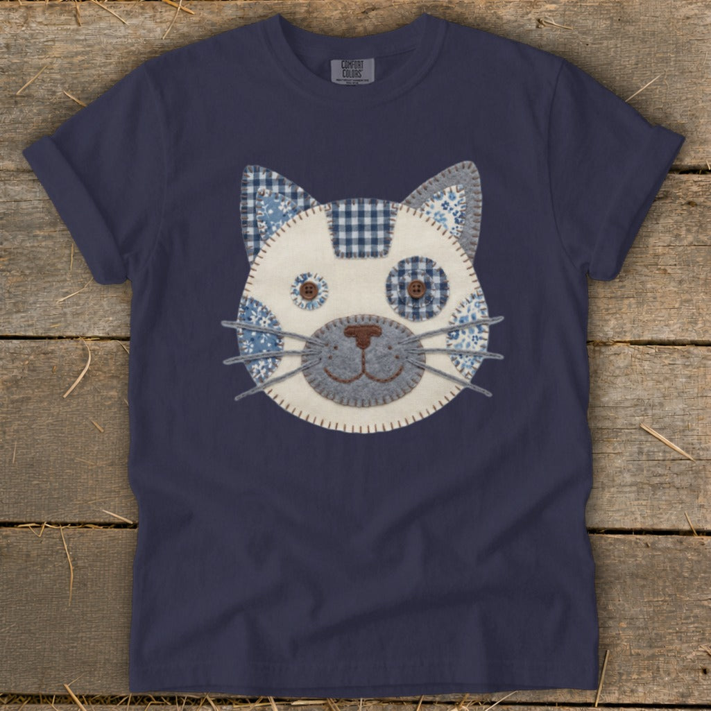 Navy blue t-shirt with a blue and white patchwork cat face applique.