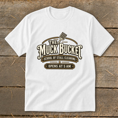 White t-shirt with "The Muck Bucket School of Stall Cleaning" logo.