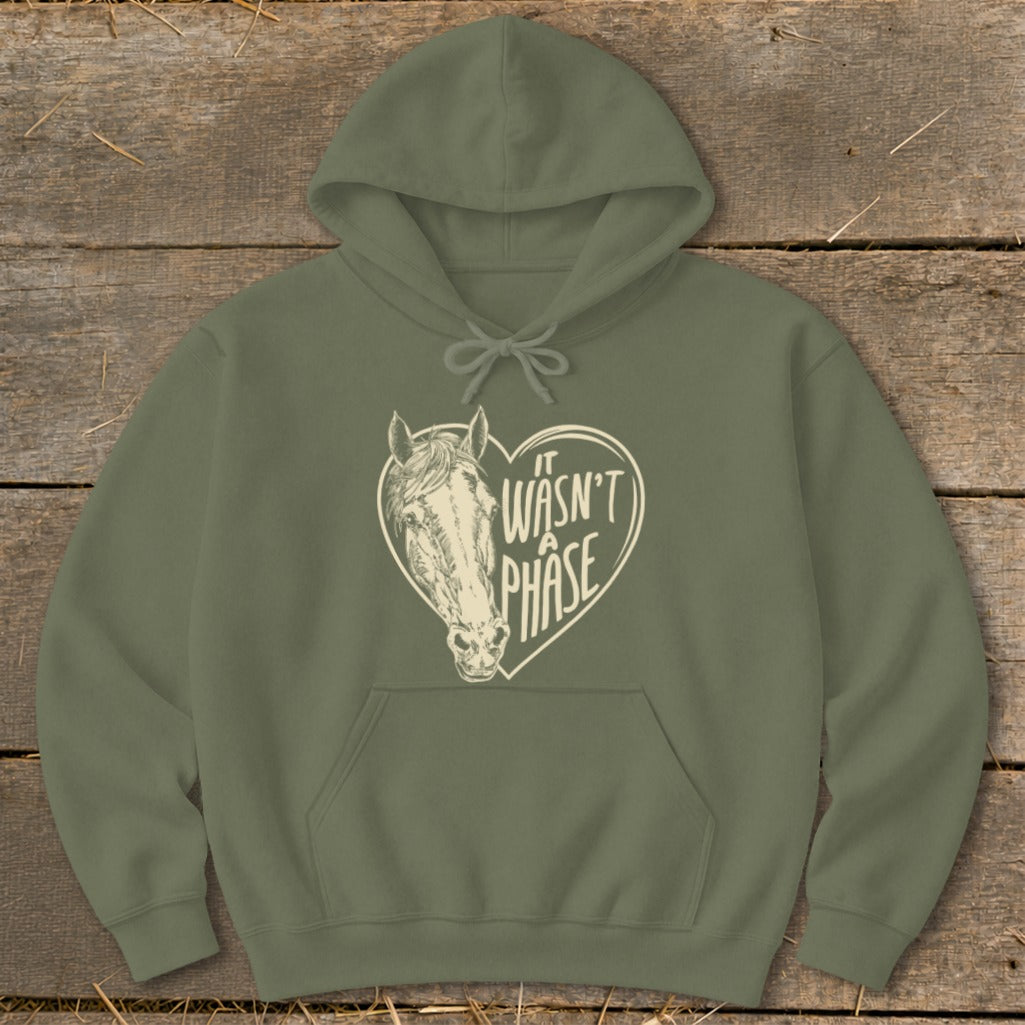 Olive green hoodie with a cream heart graphic featuring a horse and text "IT WASN'T A PHASE".