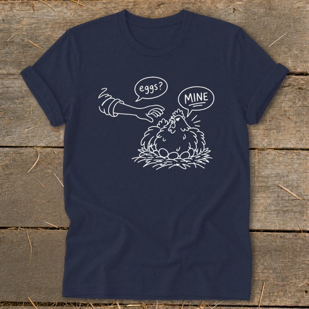 T-shirt graphic with chicken on eggs and hand asking "eggs?" with "MINE" speech bubble.