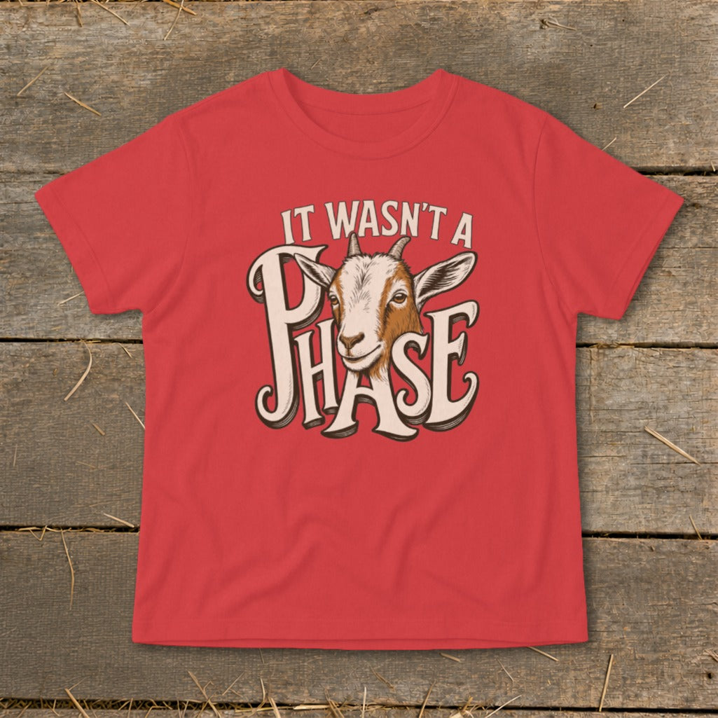 Red t-shirt with graphic of a goat's face and text "IT WASN'T A PHASE".