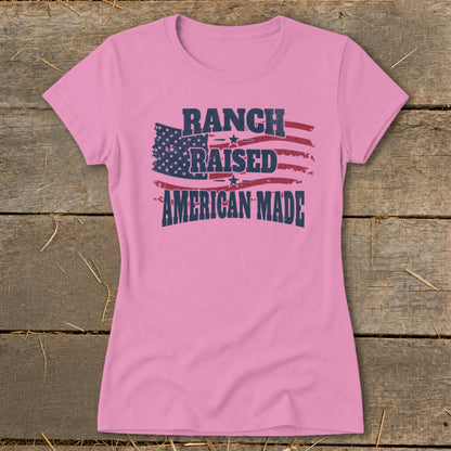 Pink t-shirt with distressed American flag and text "RANCH RAISED AMERICAN MADE."