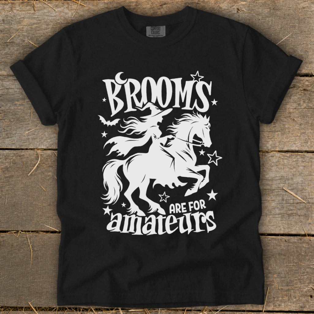 Black t-shirt with white graphic of witch riding horse, text "Brooms are for amateurs."