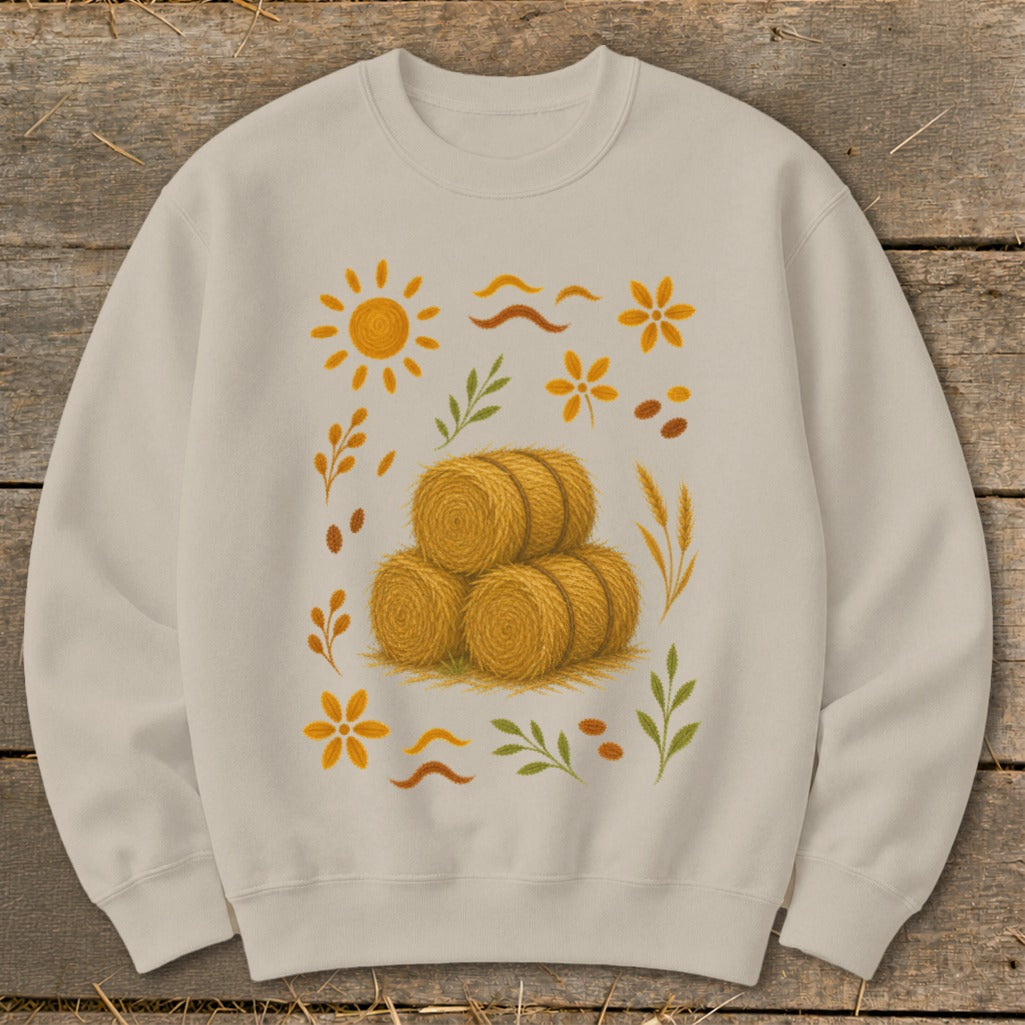 Light tan sweatshirt with a central design of hay bales and autumn-themed graphics.
