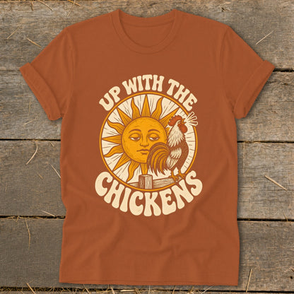 Orange t-shirt featuring a retro graphic of a crowing rooster, a smiling sun, and the text Up With The Chickens.