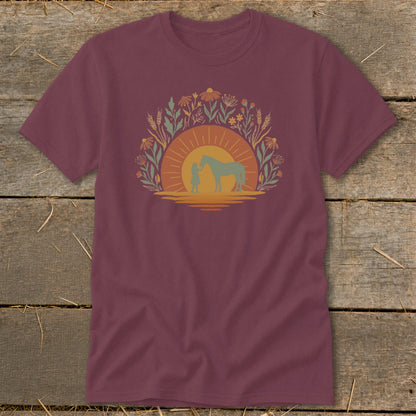 Maroon t-shirt with a sunset graphic of a girl and horse among flowers.