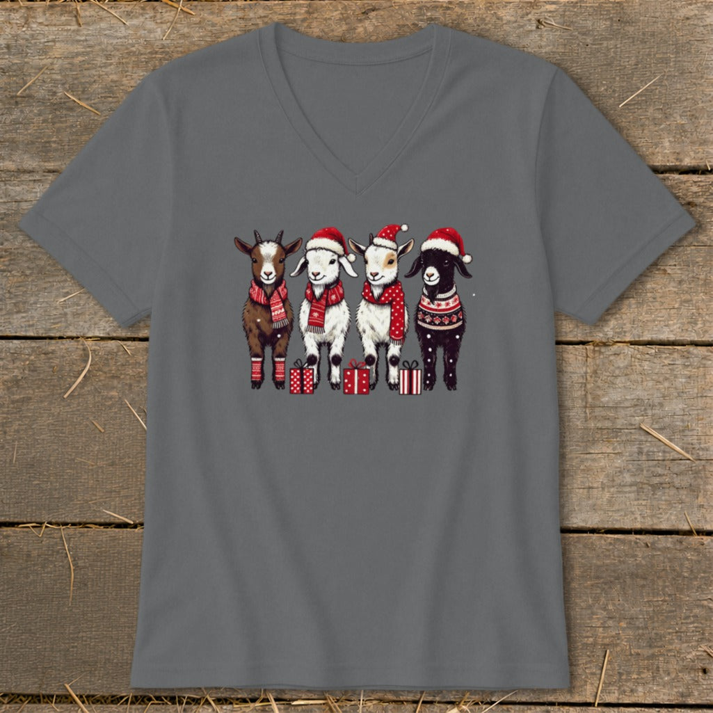 Four cartoon goats wear Santa hats, scarves, and festive sweaters, standing by presents.