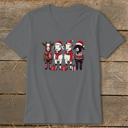 Four cartoon goats wear Santa hats, scarves, and festive sweaters, standing by presents.