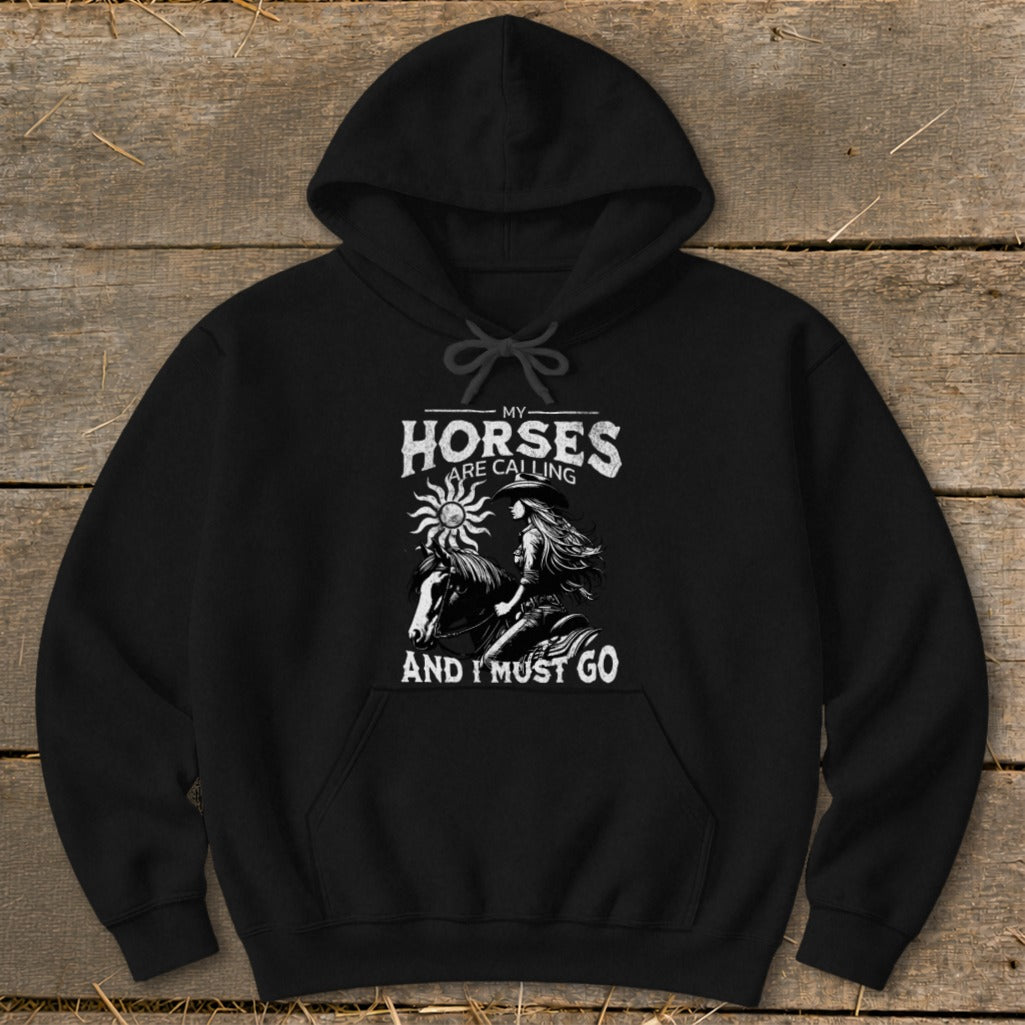 Black hoodie with white graphic of a cowboy hat-wearing woman on horseback with text "My Horses Are Calling And I Must Go".