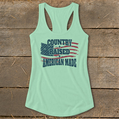 Mint green tank top with distressed American flag and text "Country Raised American Made".