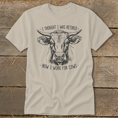 T-shirt with sketch of a cow and text "I thought I was retired - now I work for cows."