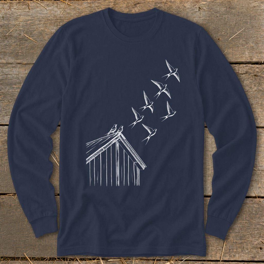 A navy blue long-sleeve t-shirt features a white sketch of birds flying from a cabin roof.