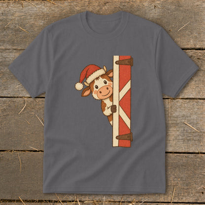 Cute cow wearing Santa hat peeks from behind a red wooden door.