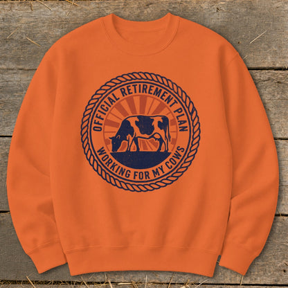 Orange crewneck sweatshirt with a circular graphic featuring a cow and text.