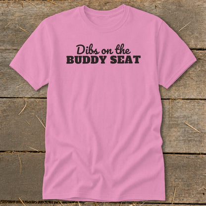 Pink t-shirt with black text "Dibs on the BUDDY SEAT".