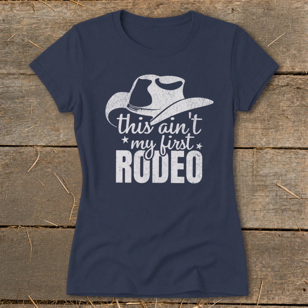 Navy t-shirt with white distressed graphic of a cowboy hat and text "this ain't my first RODEO".