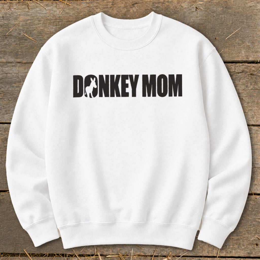 A white crewneck sweatshirt featuring the black text Donkey Mom with a donkey silhouette inside the letter O.