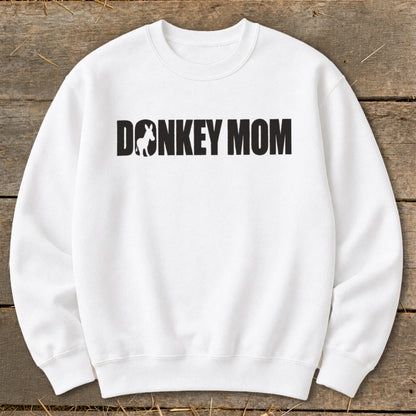 A white crewneck sweatshirt featuring the black text Donkey Mom with a donkey silhouette inside the letter O.