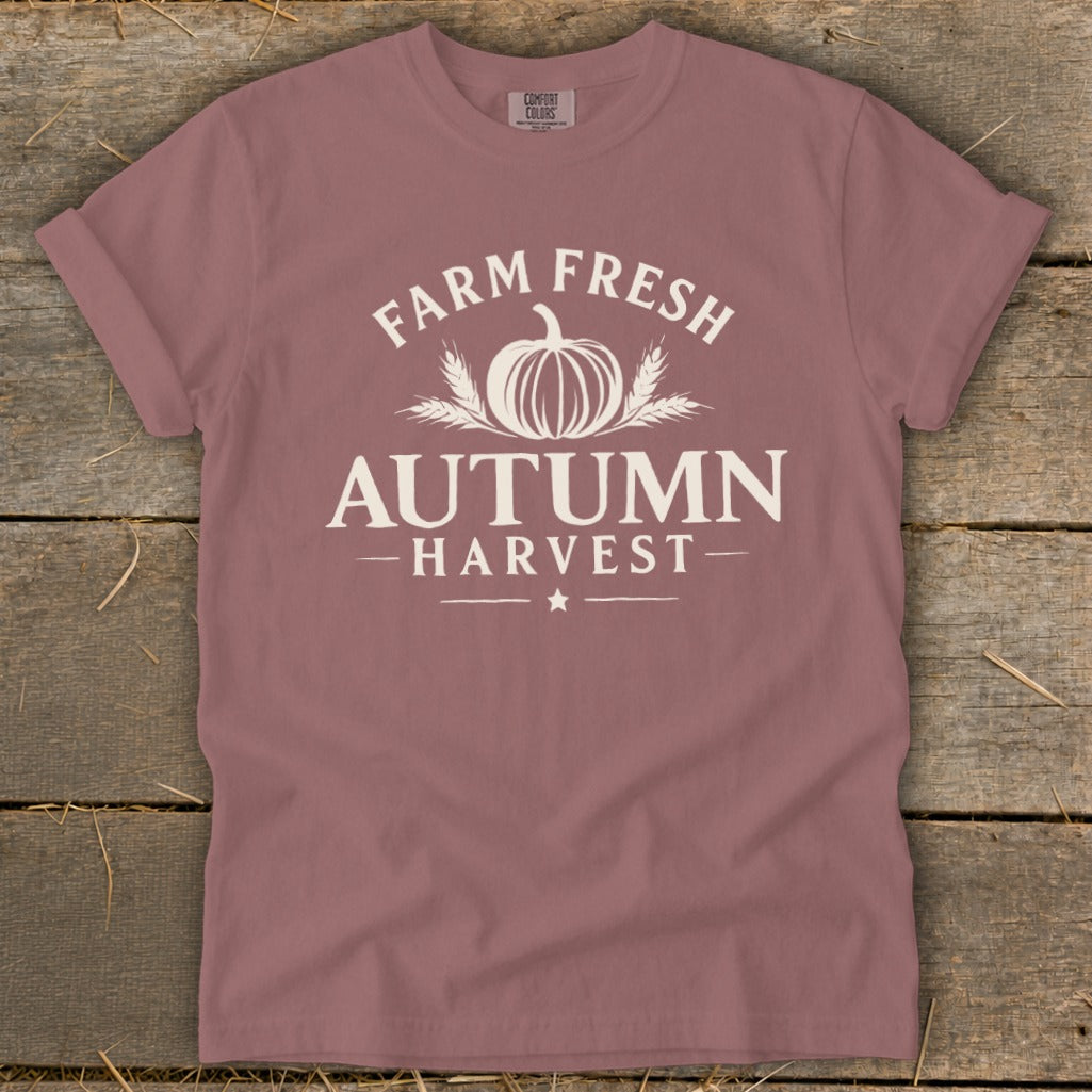 Rose colored t-shirt with white text and graphics: "Farm Fresh Autumn Harvest" with pumpkin and wheat.